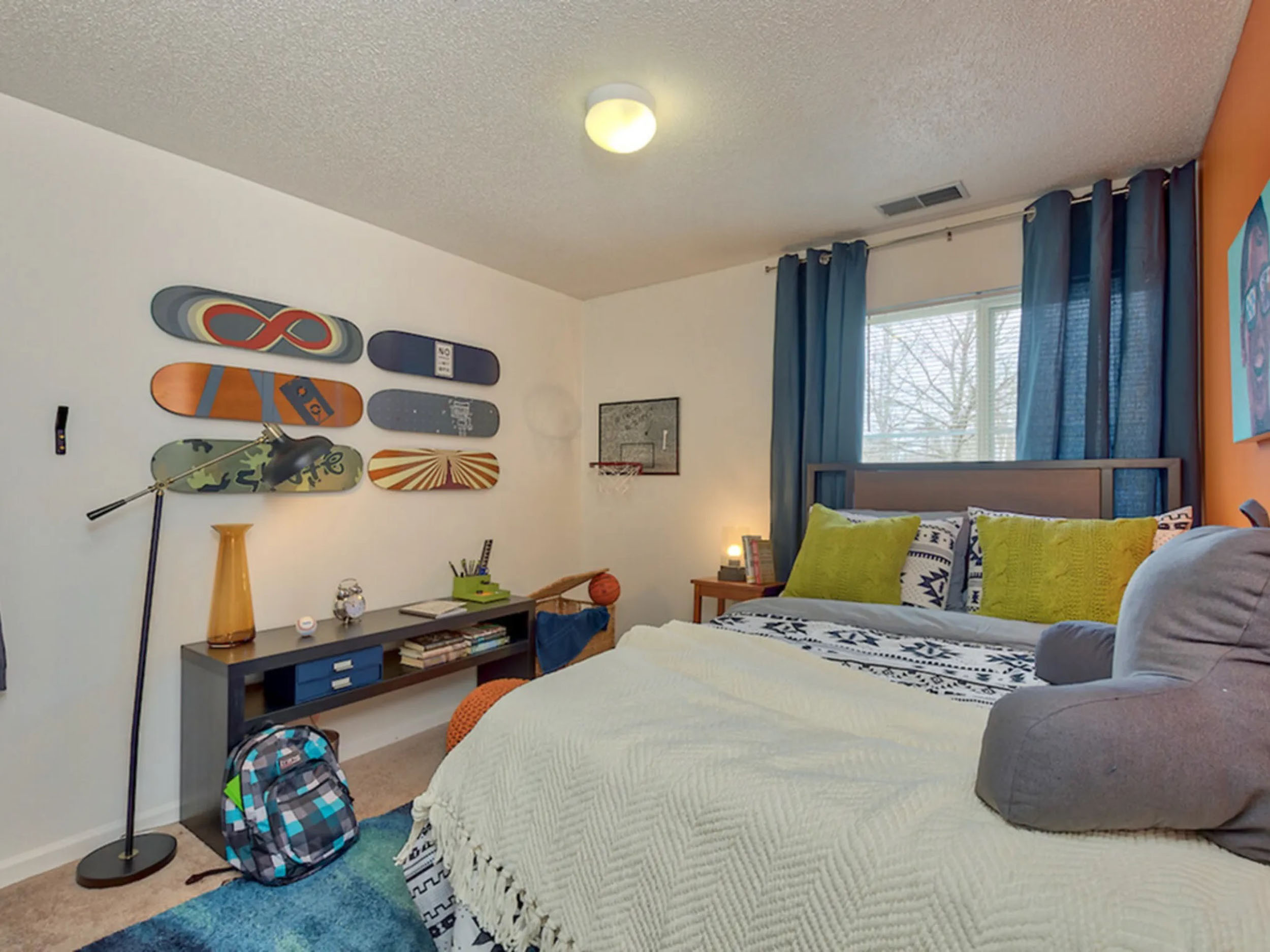 a bedroom with a bed and skateboards on the wall