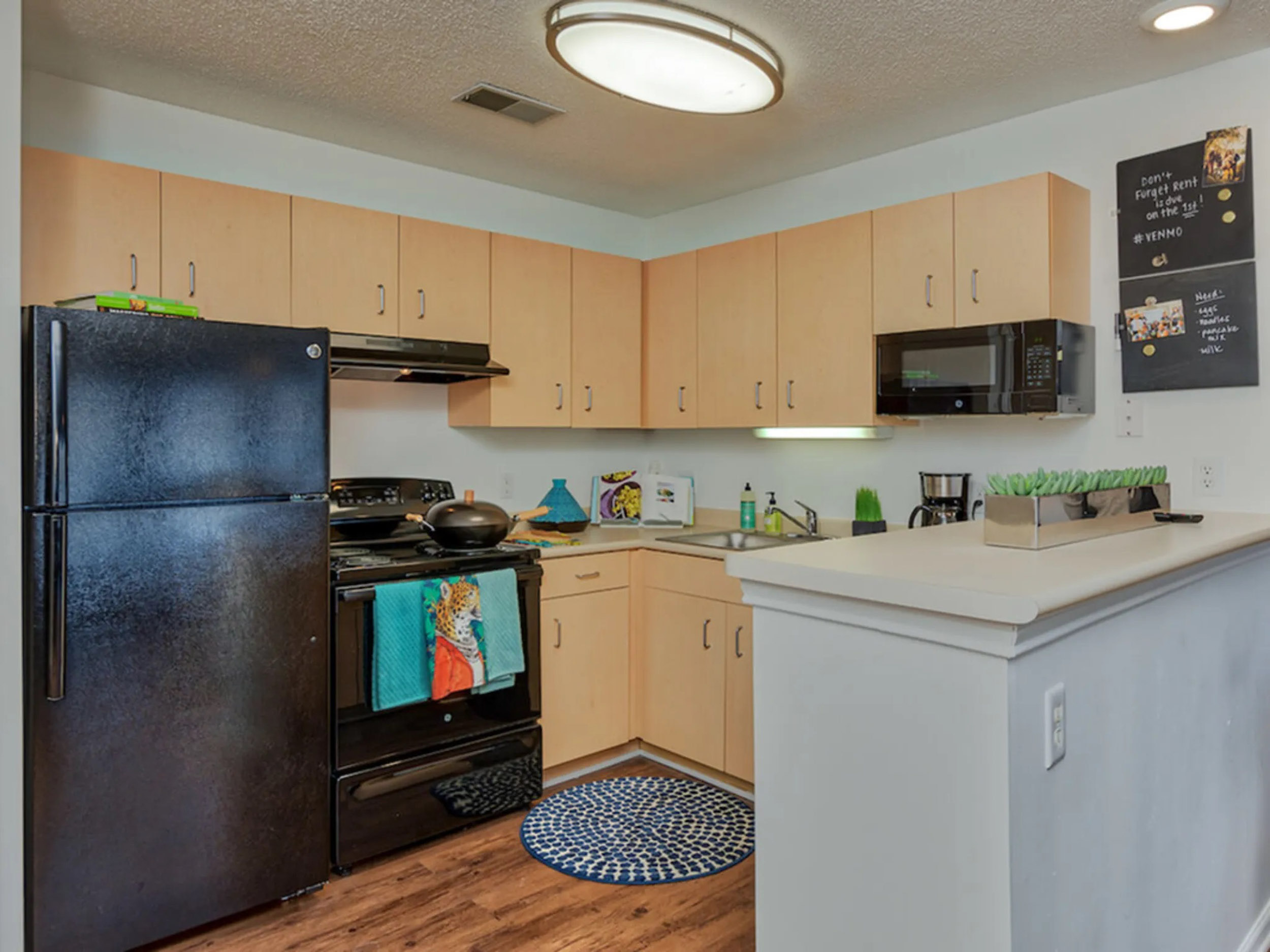 a kitchen with a black stove and wooden cabinets